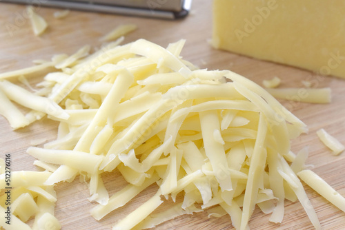 Grated cheese on a bamboo chopping board.