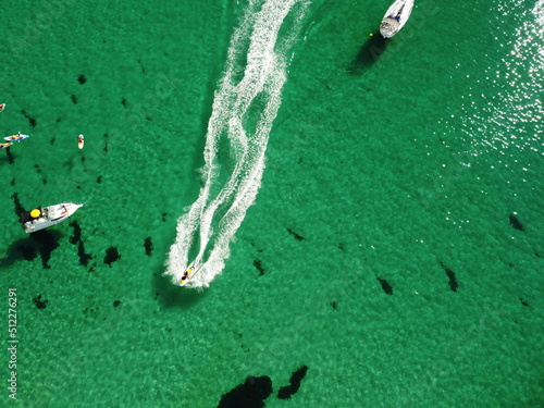 Aerial panoramic view of seascape with crystal clear azure sea and rocky shores. Yachts in a beautiful lagoon on backdrop of rocks. The concept of an ideal destination for summer travel and vacation.