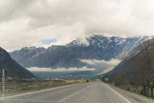 road in Kazbegi and Caucasus mountains in the background, Georgia. High quality photo © PoppyPix
