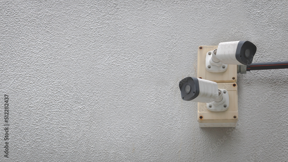 Closeup of white cctv digital security camera installed on cement wall for observation. Surveillance and safety monitoring concept. Closeup of white cctv digital security camera installed on cement wall for observation. Surveillance and safety monitoring concept.