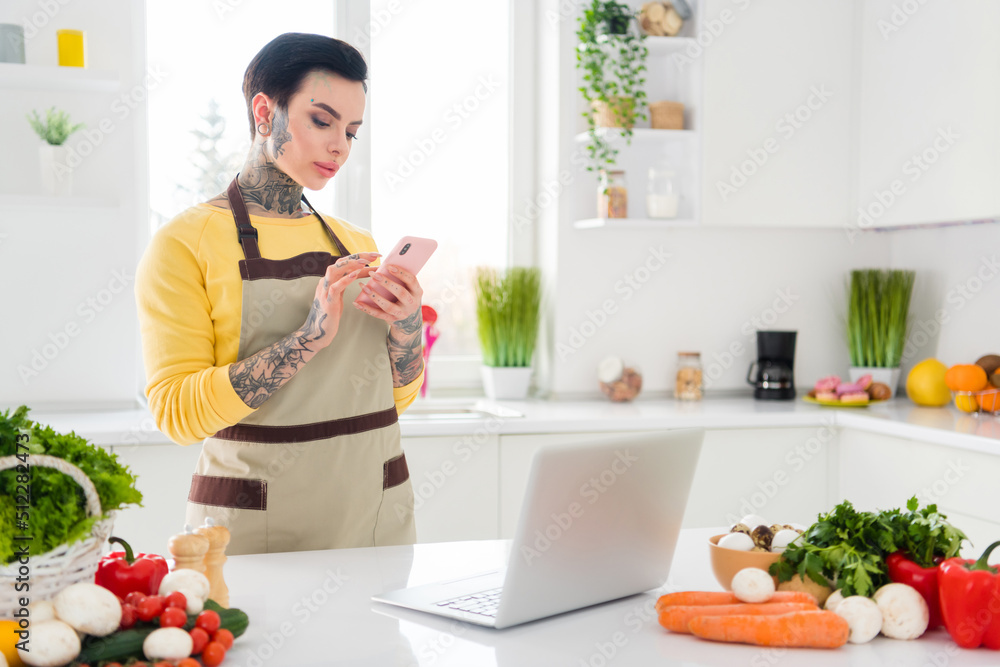 Photo of young stunning female with tattoos piercing chatting with boyfriend in phone prepare romantic dinner Photo of young stunning female with tattoos piercing chatting with boyfriend in phone prepare romantic dinner