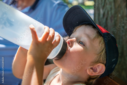 enfant buvant avec une gourde photo