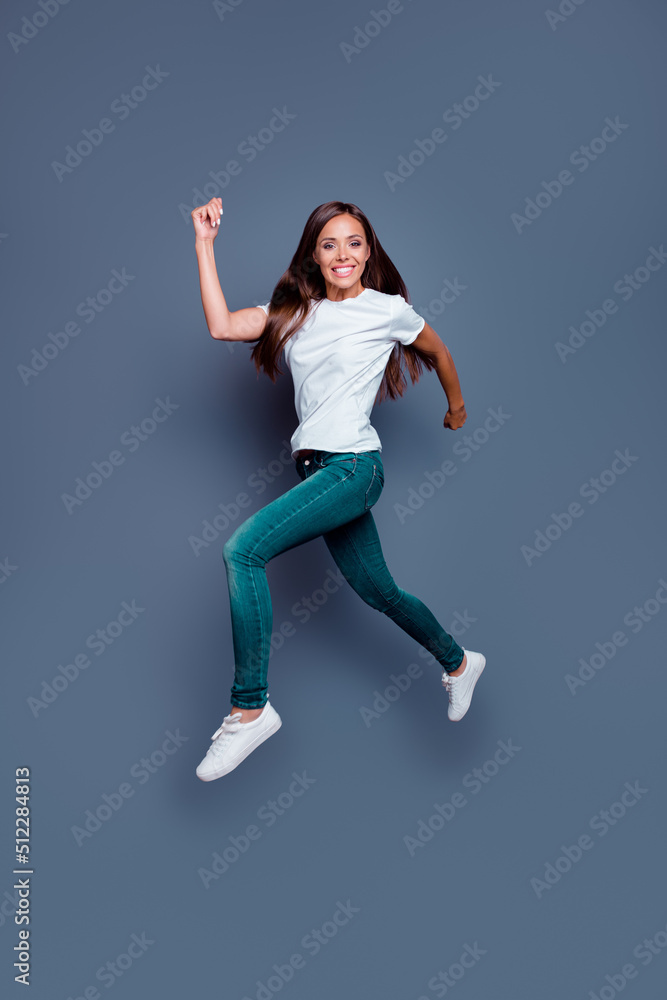 Full body portrait of active satisfied lady jump running rush fast have good mood isolated on grey color background Full body portrait of active satisfied lady jump running rush fast have good mood isolated on grey color background