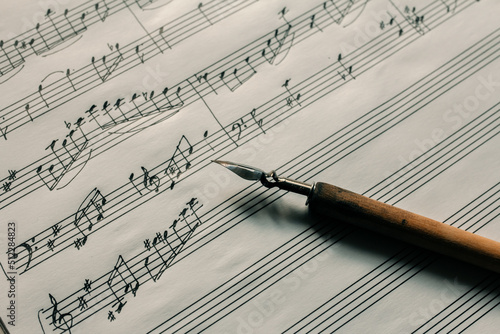 Ink pen on the background of a lined sheet with notes, writing notes, composing music