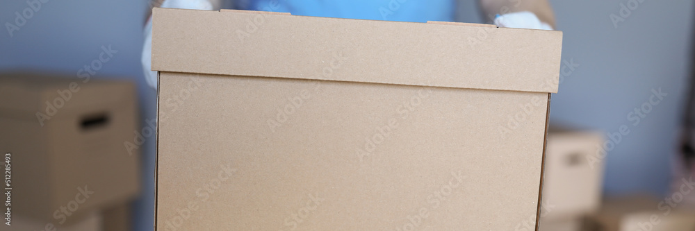Worker loading cardboard boxes with owners belongings to new apartment Worker loading cardboard boxes with owners belongings to new apartment