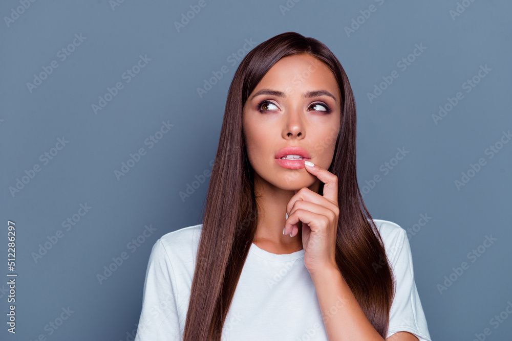Photo of pretty minded girl finger touch lips look interested empty space isolated on grey color background Photo of pretty minded girl finger touch lips look interested empty space isolated on grey color background