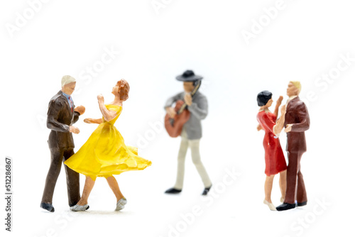 Miniature people Couple dancing with a guitarist playing the guitar on white background