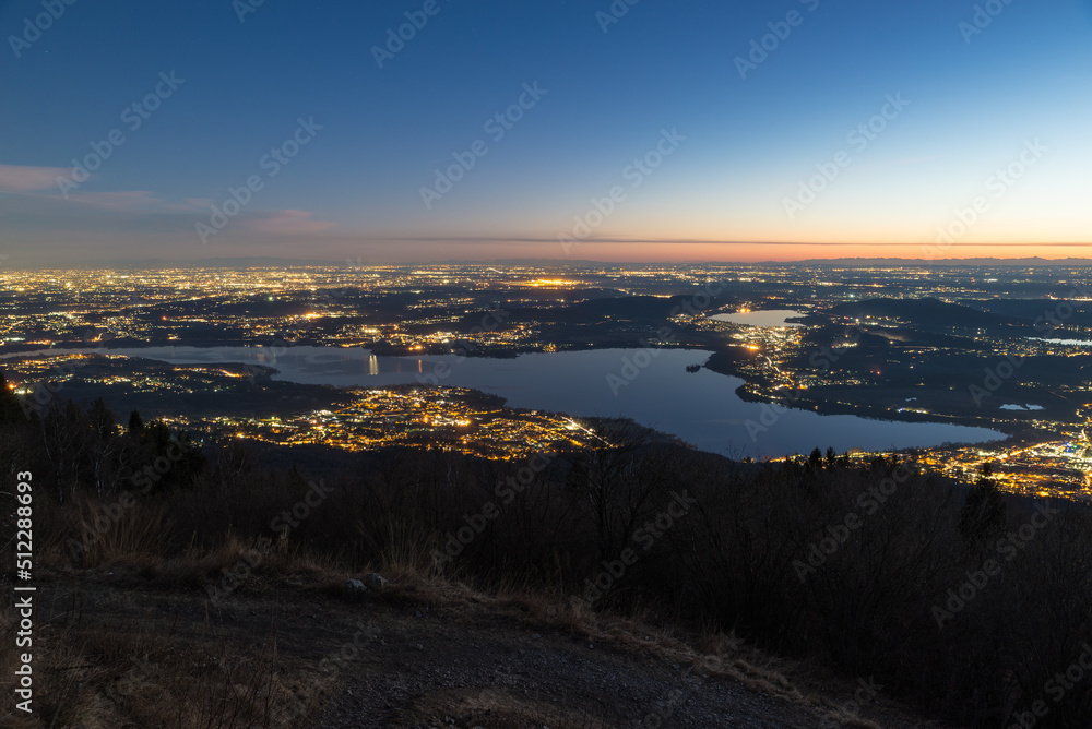 Aerial view of Lombardy and northern Italy at dusk with Lake Varese in the foreground and the Apennines on the horizon. Panorama at sunset from the Campo dei Fiori regional park in Varese