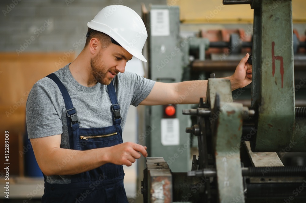 worker in protective clothing in factory using machine worker in protective clothing in factory using machine