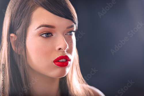 Semi-profile of Beautiful Caucasian Woman With Cat Blue Eyes, Full Red Lips and Open Mouth Looking Away on Grey Empty Background