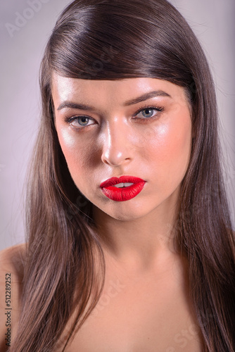 Portrait of a Beautiful Caucasian Woman With Cat Blue Eyes, Full Red Lips and Open Mouth on Grey Background
