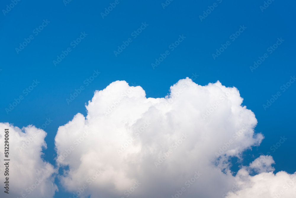 White cloud, gray at base on blue sky background. Half of the image is blue sky White cloud, gray at base on blue sky background. Half of the image is blue sky