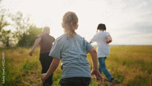 group of children a run in the park. little children are happy running on the grass in the summer playing in the forest. happy family kindergarten kids dream lifestyle concept © maxximmm