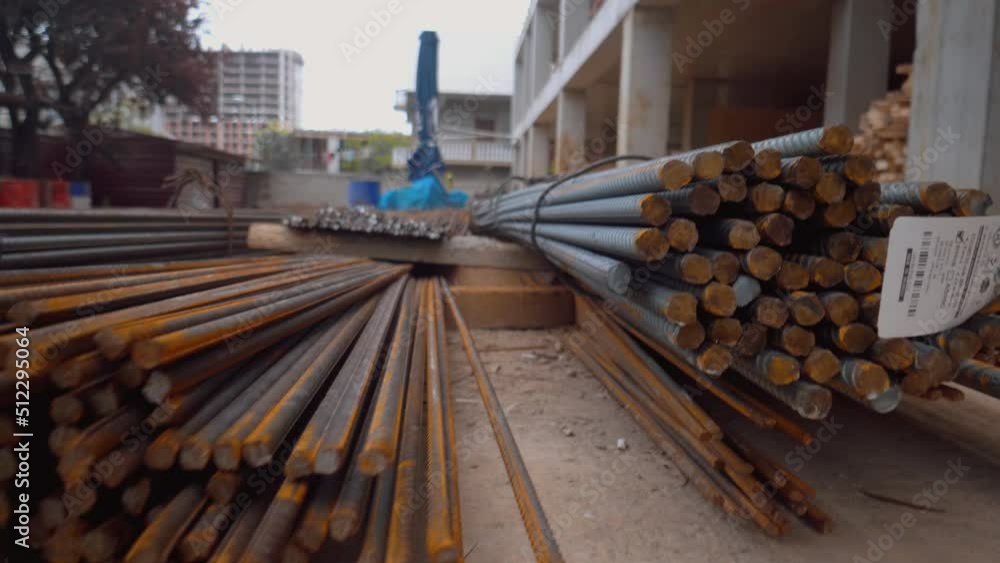 Bars of reinforcement are stacked in yard of construction site. Large number of metal bars lie for strapping foundation. Close-up of camera movement. Rust and dirt. Bars of reinforcement are stacked in yard of construction site. Large number of metal bars lie for strapping foundation. Close-up of camera movement. Rust and dirt.