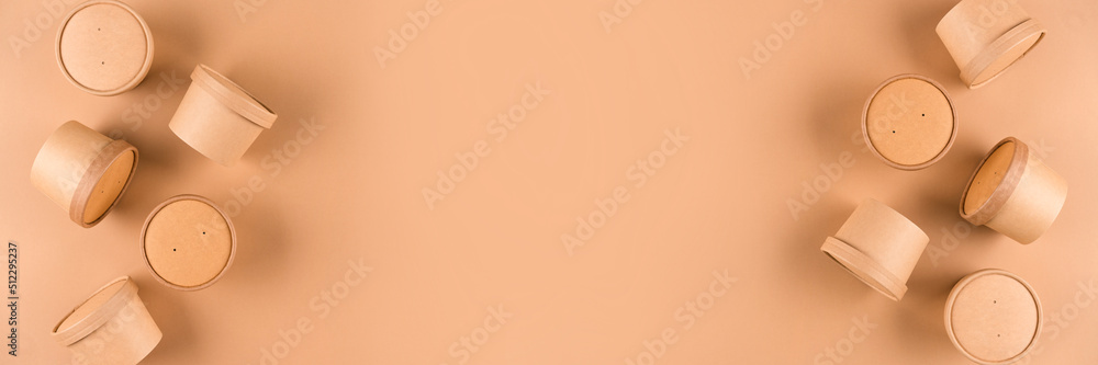 Bannner with disposable kraft paper soup or ice cream containers with paper cap over light brown background with copy space, mockup. Sustainable food packaging concept Bannner with disposable kraft paper soup or ice cream containers with paper cap over light brown background with copy space, mockup. Sustainable food packaging concept