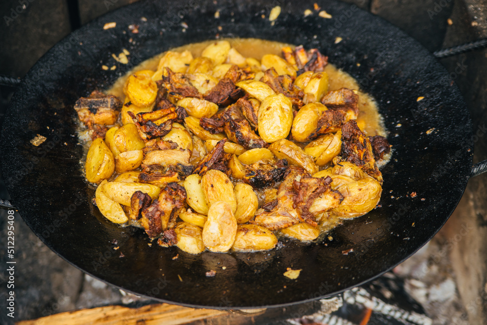 Close-up of summer meat with vegetables, onions and potatoes, which is fried in a cauldron. View from above. Caucasian or Asian cuisine. Close-up of summer meat with vegetables, onions and potatoes, which is fried in a cauldron. View from above. Caucasian or Asian cuisine.
