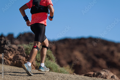 Trail running athlete exercising for fitness and health outdoors on mountain pathway © pavel1964