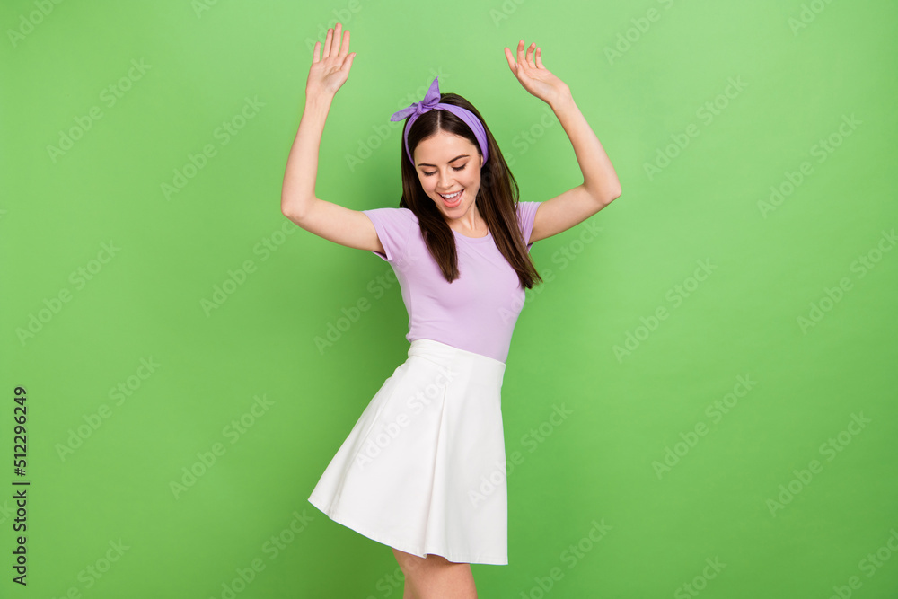 Photo of impressed brunette lady dance wear purple t-shirt band skirt isolated on green color background Photo of impressed brunette lady dance wear purple t-shirt band skirt isolated on green color background