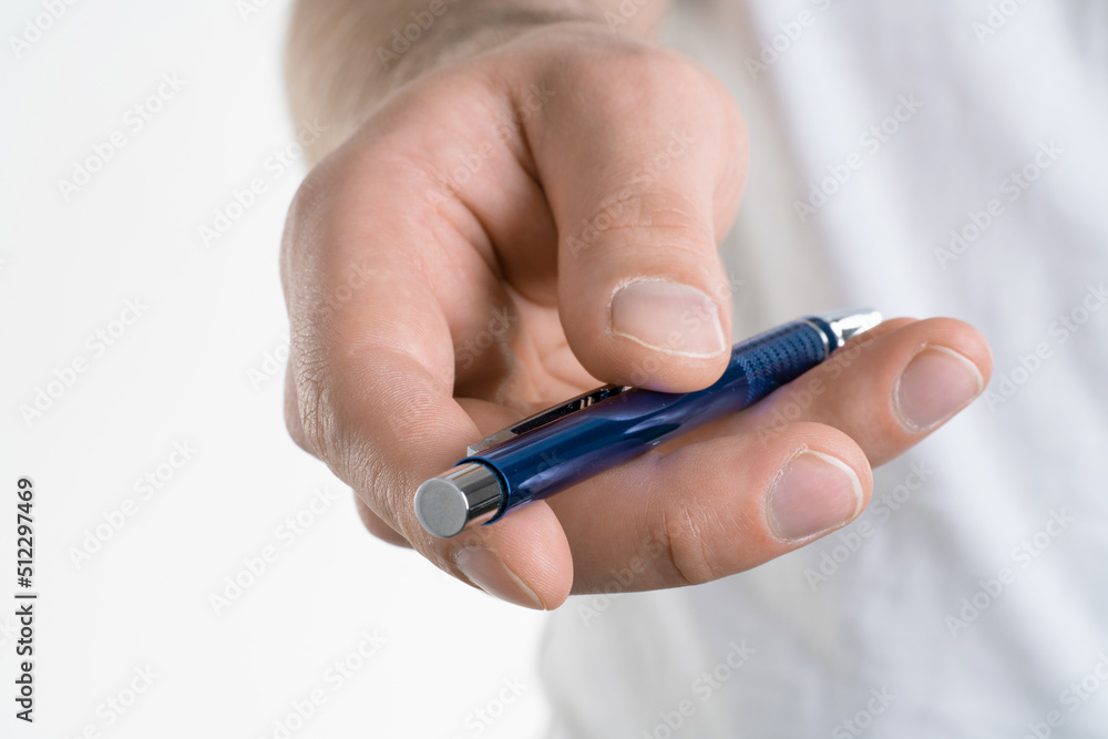 A close up image of Man's hand holds a pen isolated on white background. Giving pen to sign form or something A close up image of Man's hand holds a pen isolated on white background. Giving pen to sign form or something