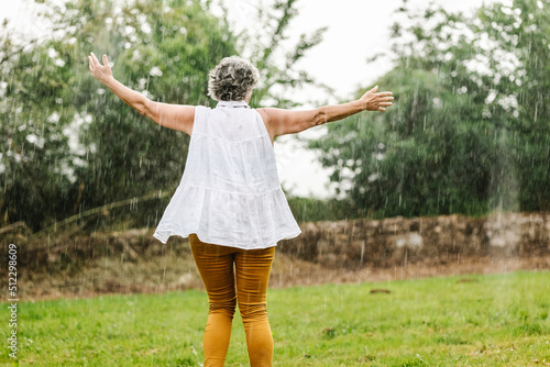 Anonymous woman dancing in rain photo