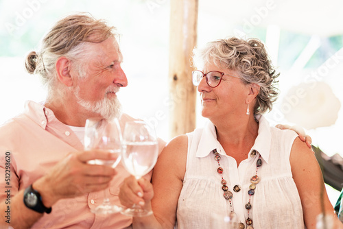 Elderly couple clinking glasses with water during wedding celebration photo
