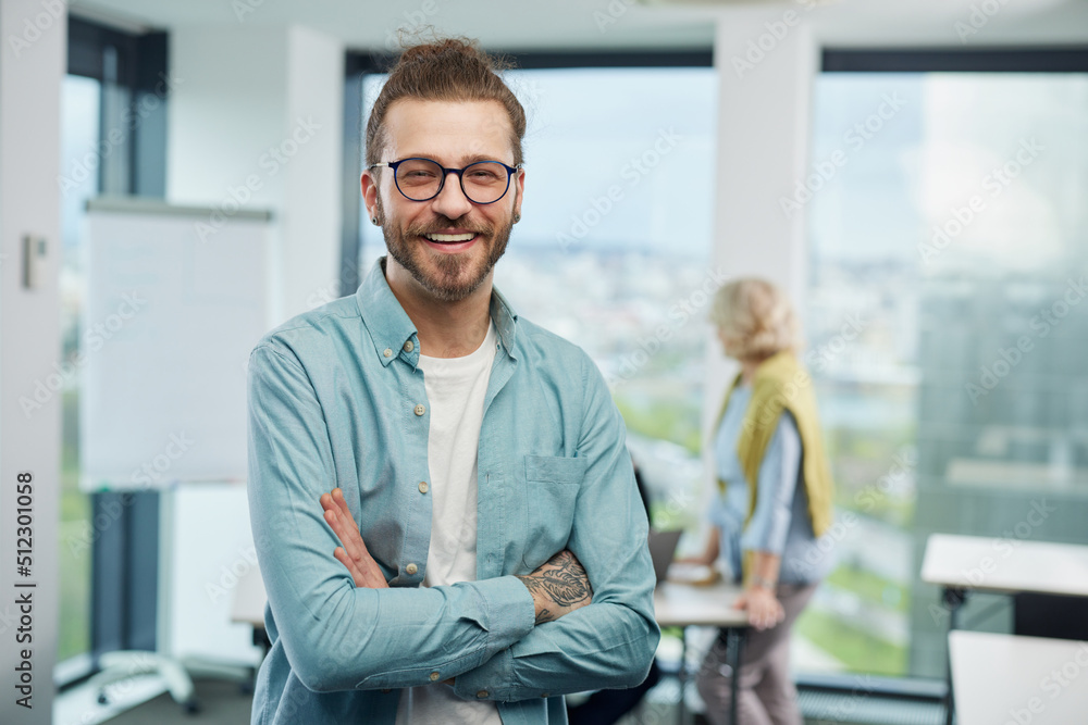 A happy, successful young professor is standing in a classroom and smiling at the camera. A happy, successful young professor is standing in a classroom and smiling at the camera.