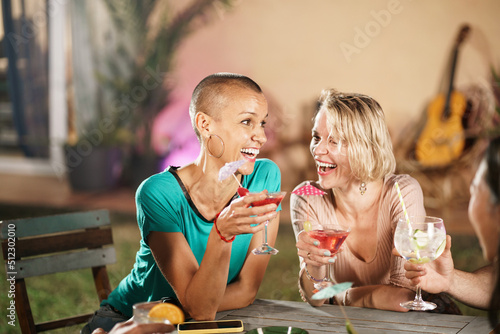 Canvas Print Two female friends drinking cocktails in an outdoors garden party - Happy women