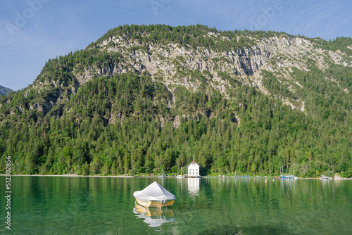 A beautiful alpine lake. Small boat at the pier on lake Plansee in the European Alps  in Austria.