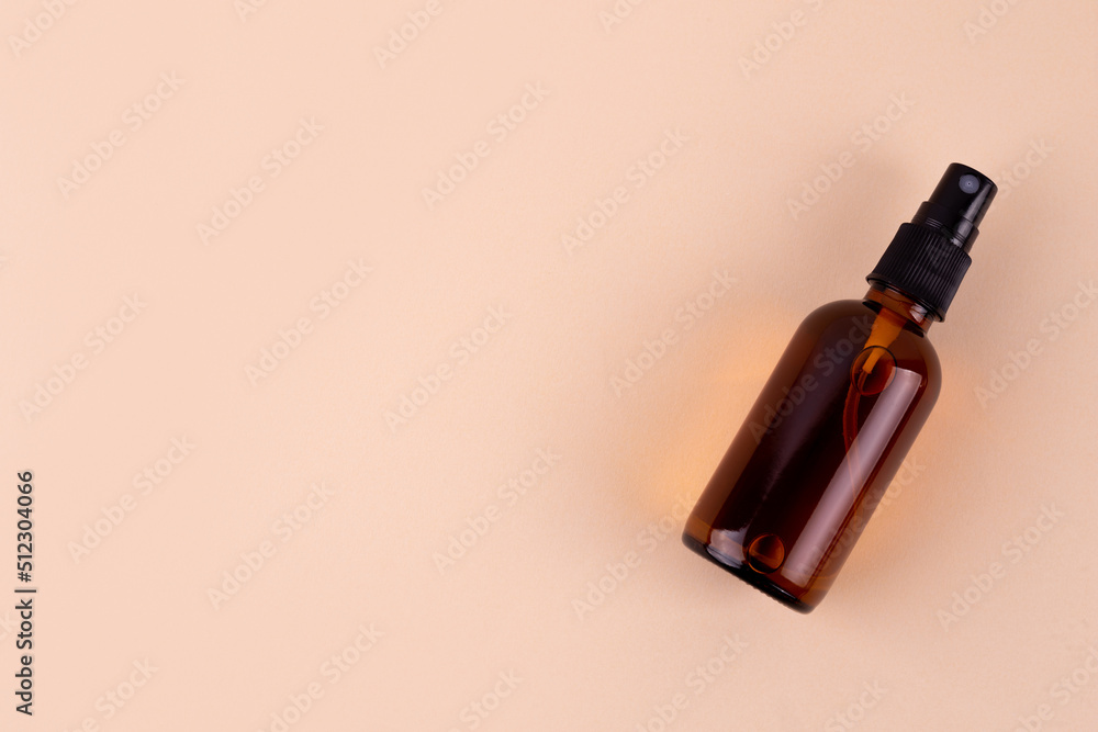 Unbranded bottle with dispenser. Brown glass container with oil for body and hair. Mockup style design. Cosmetology and beauty concept Unbranded bottle with dispenser. Brown glass container with oil for body and hair. Mockup style design. Cosmetology and beauty concept