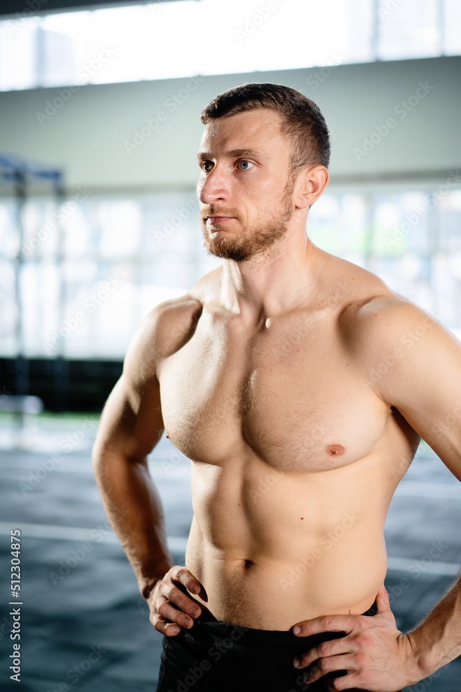 Fototapeta premium Athletic man posing hardcore in the gym