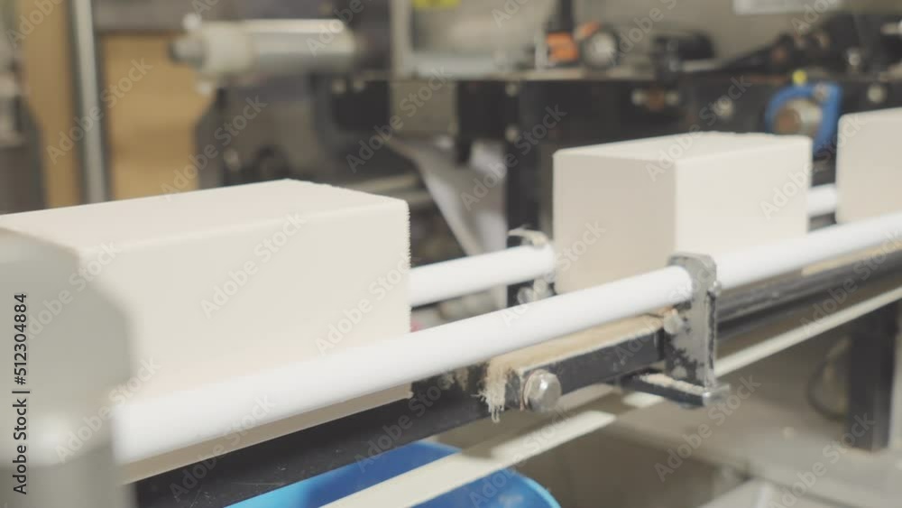 Conveyor of the food industry. An enterprise that produces butter, spread, margarine, yeast. Rectangular pieces of product move along the line before packing Conveyor of the food industry. An enterprise that produces butter, spread, margarine, yeast. Rectangular pieces of product move along the line before packing