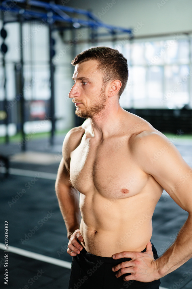 Obraz premium Athletic man posing hardcore in the gym