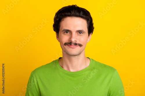 Photo of calm satisfied young man look camera new haircut isolated on yellow color background