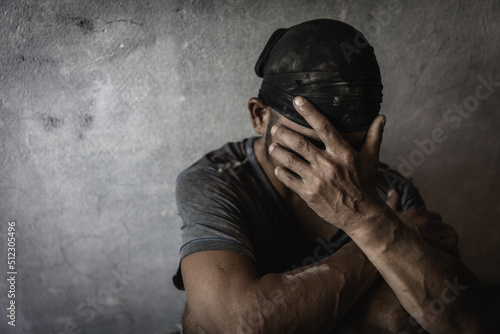 Men who show stress and loneliness, Homeless man drug  addict sitting alone and depressed  at an abandoned house feeling anxious and lonely, social documentary concept, Copy space