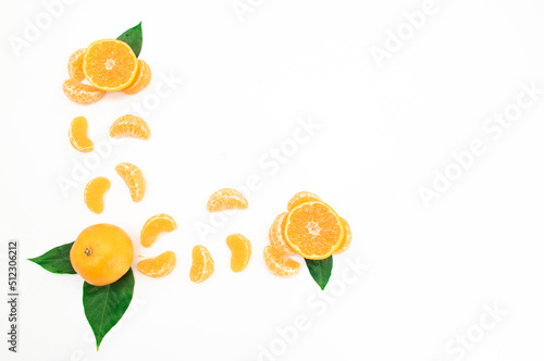 Tangerine or komola pieces with green leaf isolated on white background photo