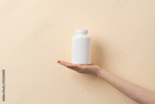 Femal hand holds a bottle of medication pills