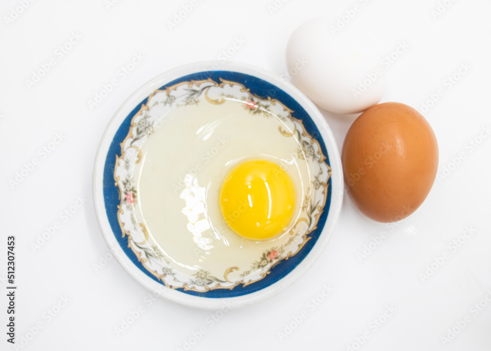Two whole eggs and one broken isolated on a white background.