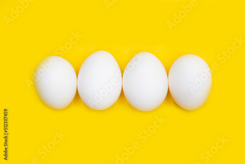 white chicken egg isolated on yellow background