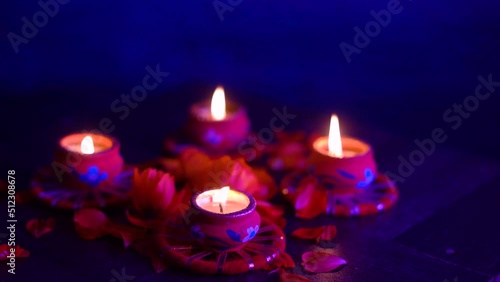 Colorful Diwali oil lamps, Deepavali oil lamps lighted in beautiful formation with flowers in middle. Oil lamps with sparkler. Motion of igniting hand held sparkler crackers photo