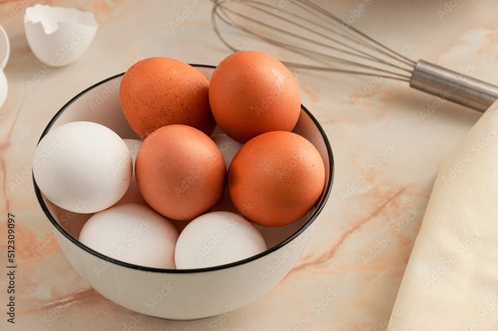 Eggs in a ceramic cup close-up. Cooking in the kitchen. White and brown eggs. Sunny morning. Preparing breakfast. selective focus Eggs in a ceramic cup close-up. Cooking in the kitchen. White and brown eggs. Sunny morning. Preparing breakfast. selective focus