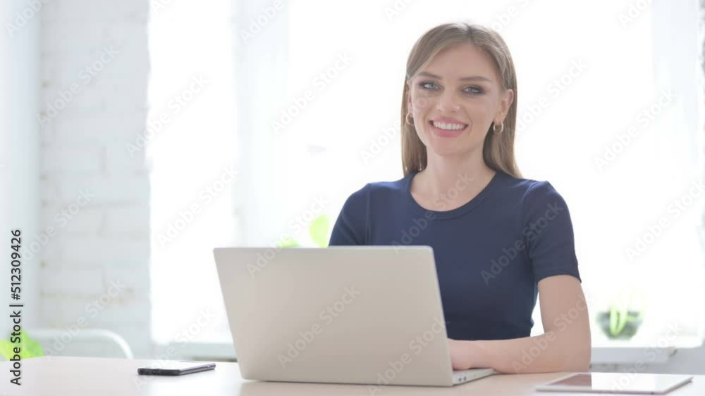 Woman Smiling at Camera while using Laptop Woman Smiling at Camera while using Laptop