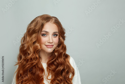 Beauty fashion portrait of beautiful cheerful smiling redhead woman with long ginger hair on white background photo
