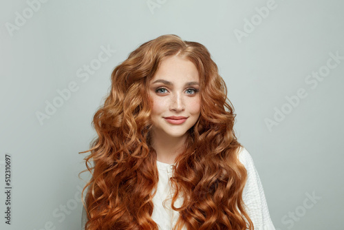 Attractive happy optimistic friendly redhead woman with long wavy ginger hair on white background