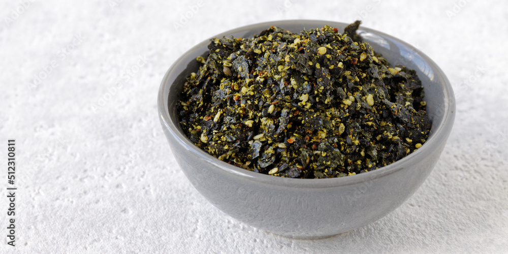 Vegan furikake seasoning with torn nori seaweed. Japanese cuisine condiment in bowl. Vegan furikake seasoning with torn nori seaweed. Japanese cuisine condiment in bowl.