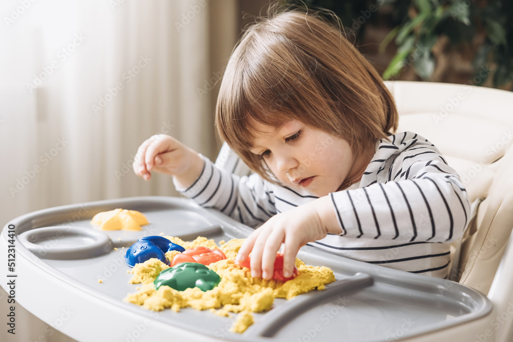 Cute little boy playing with kinetic sand. Development of fine motor skills. Early sensory education. Activities Montessori. Sensory plays at home. Cute little boy playing with kinetic sand. Development of fine motor skills. Early sensory education. Activities Montessori. Sensory plays at home.