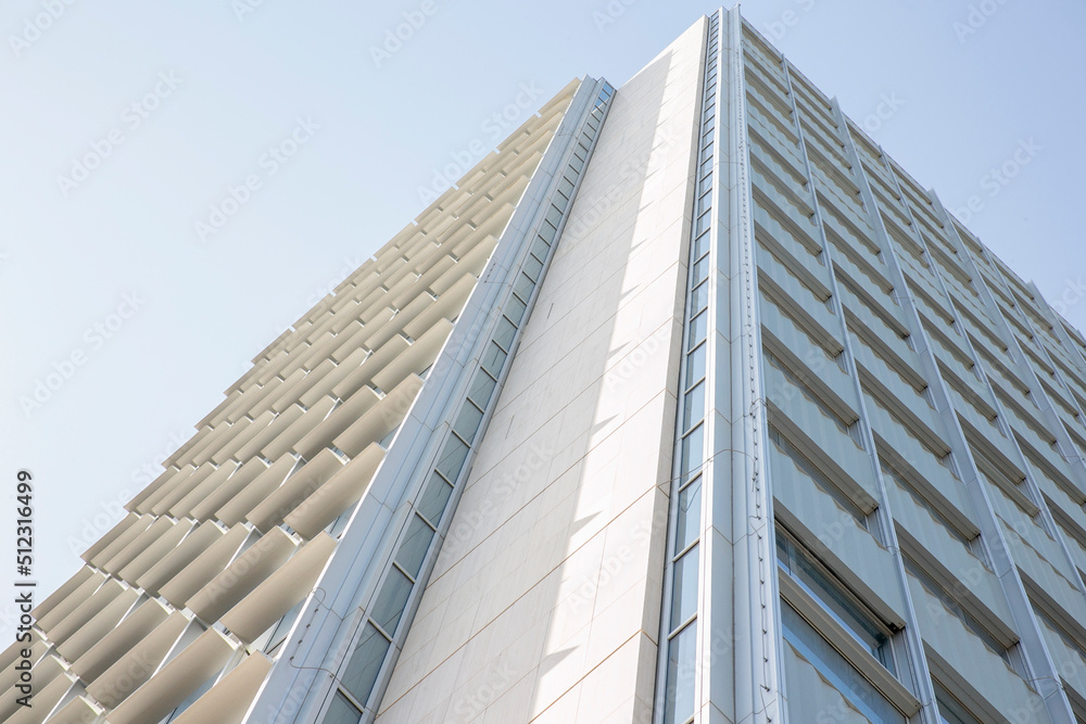 A tall office building seen from below. Behind a cloudless blue sky. The palace is located in the EUR district in Rome, Italy.