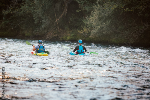 Two whitewater kayakers paddling on the waters of river. Adrenaline seekers and nature lovers. © 24K-Production