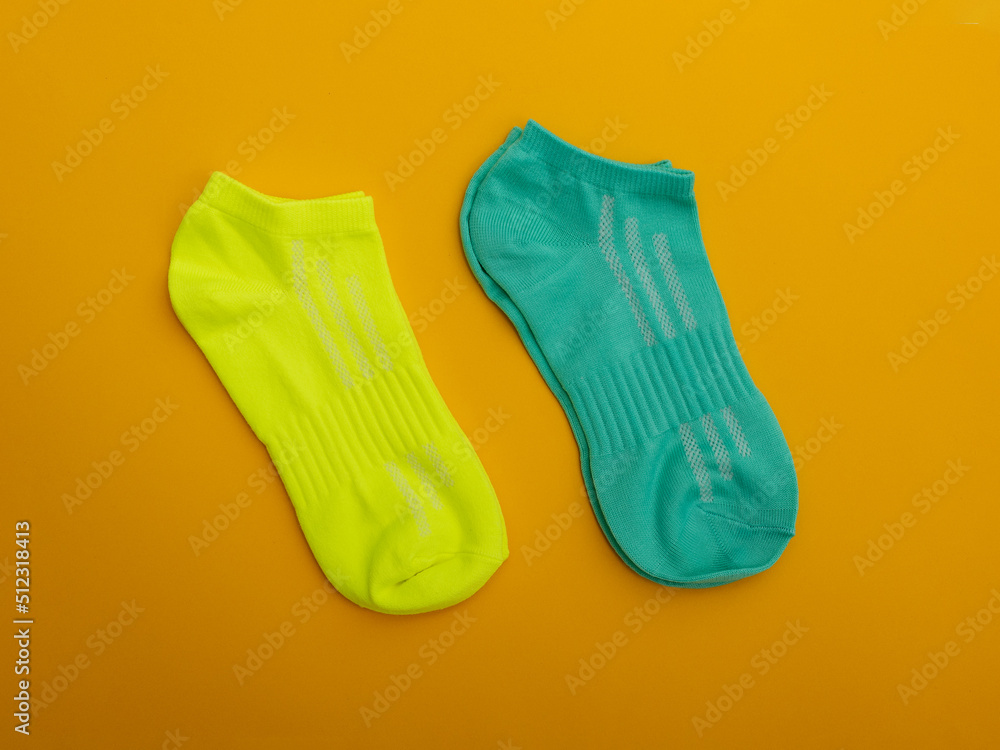 Two pairs of multicolored socks on a yellow background. Two pairs of multicolored socks on a yellow background.