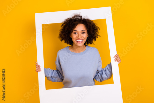 Fotografi Photo of cheerful charming lady toothy smile hold album set card window isolated