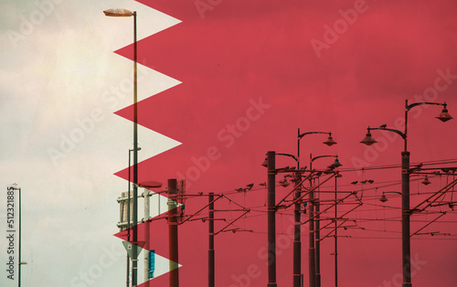 Bahrain flag with tram connecting on electric line with blue sky as background, electric railway train and power supply lines, cables connections and metal pole overhead catenary wire